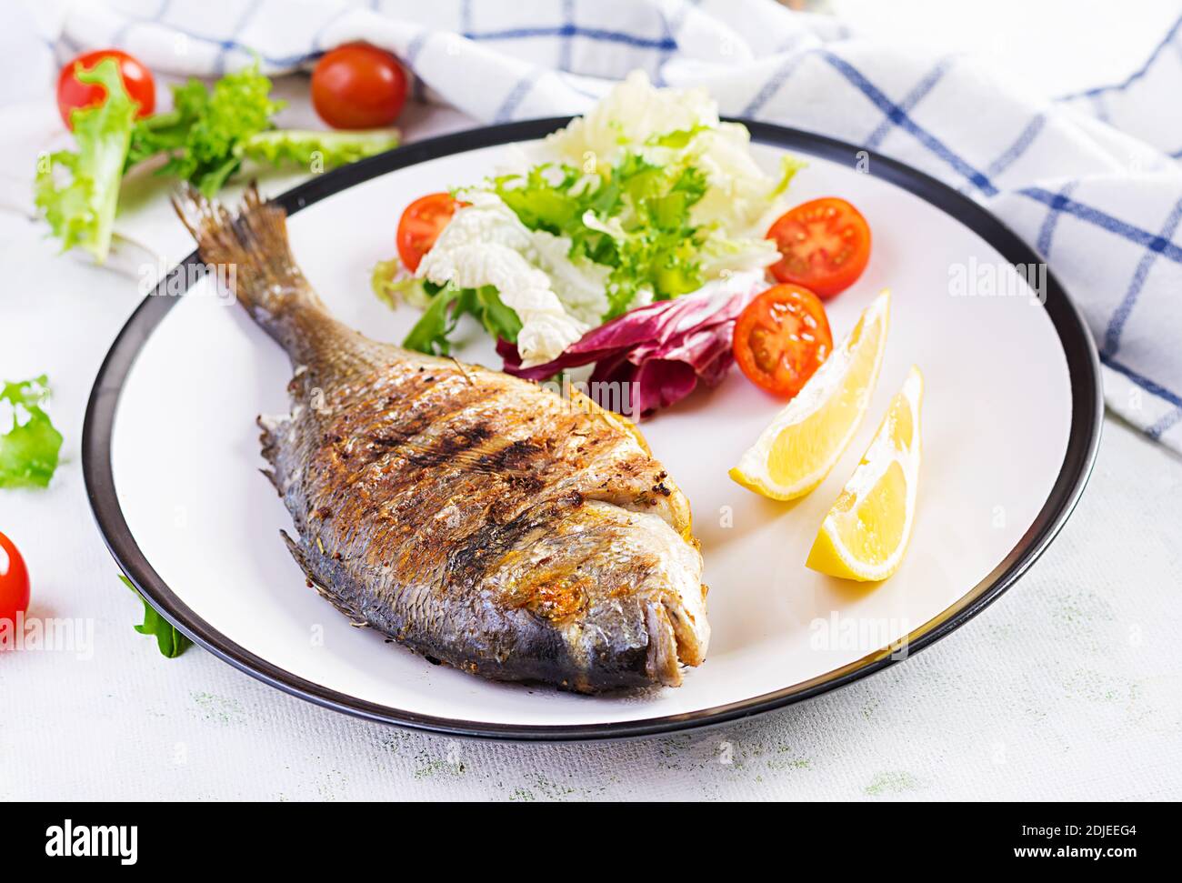 Delicious grilled dorado or sea bream fish with salad, spices, grilled  dorada on a plate Stock Photo - Alamy