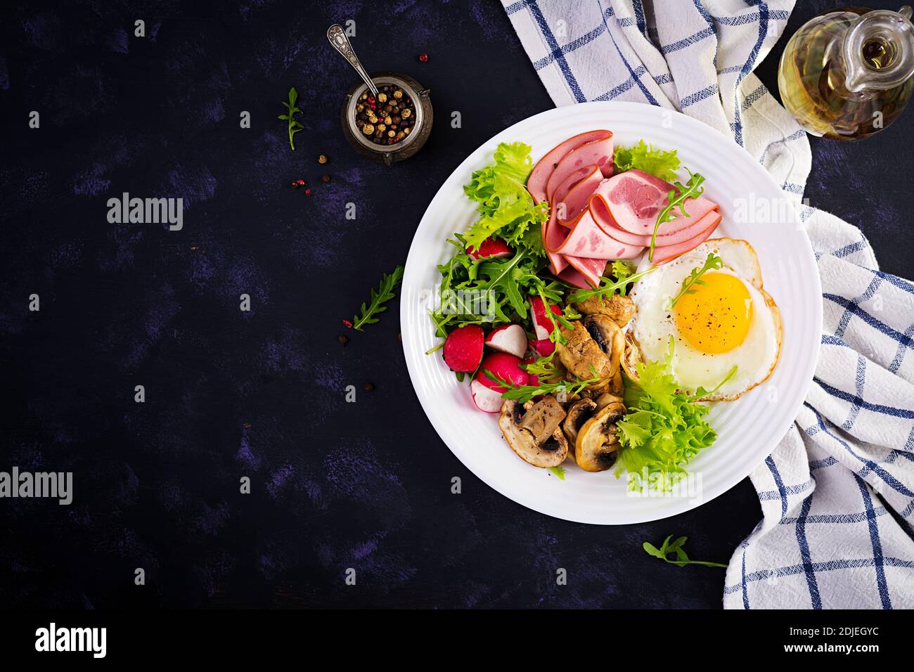 English  breakfast - fried eggs, ham, fried mushrooms, radish and arugula. ketogenic, keto  food. Top view, overhead, copy spac Stock Photo