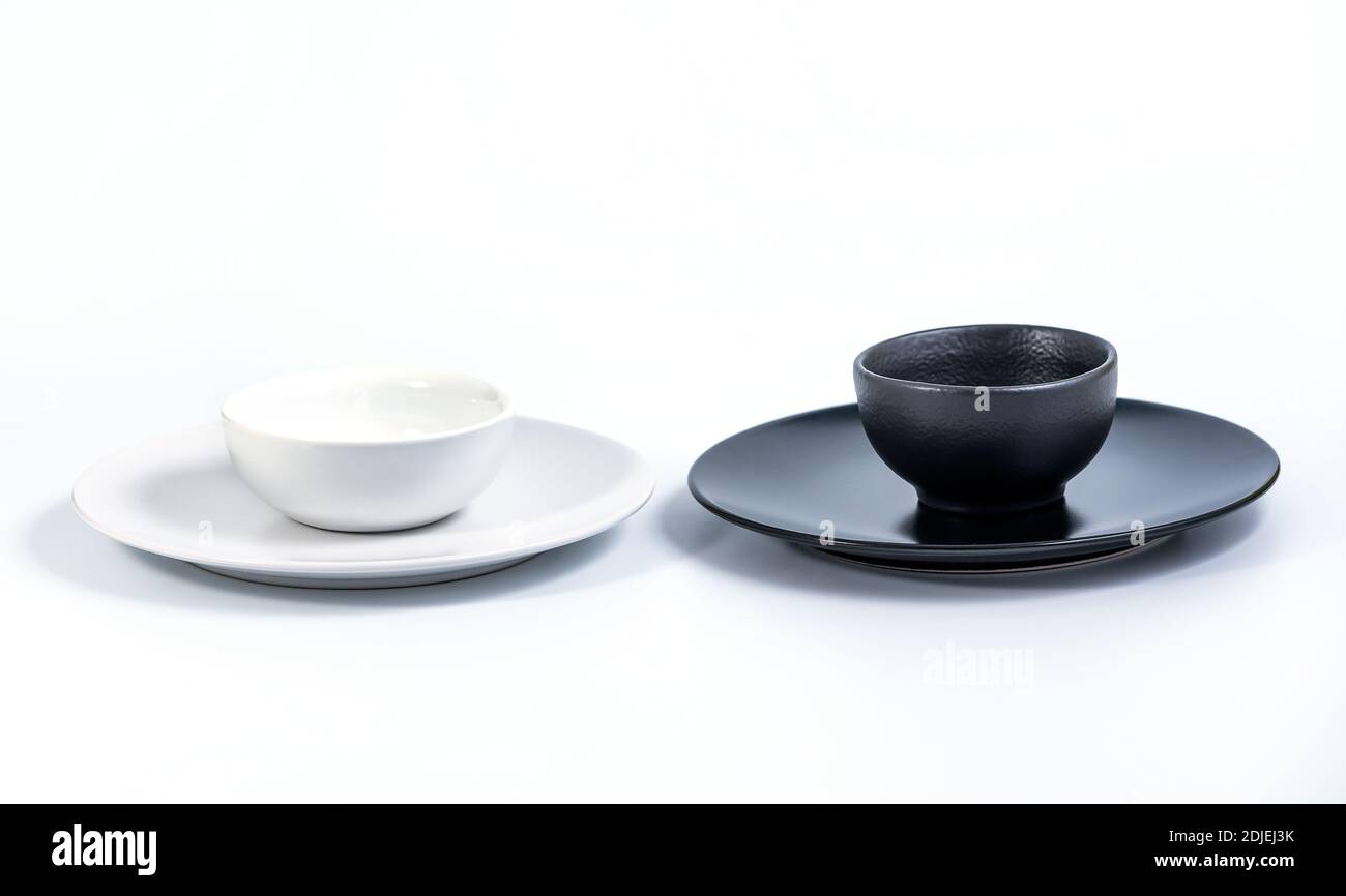 White and Black Bowls in White and Black Plates isolated on white