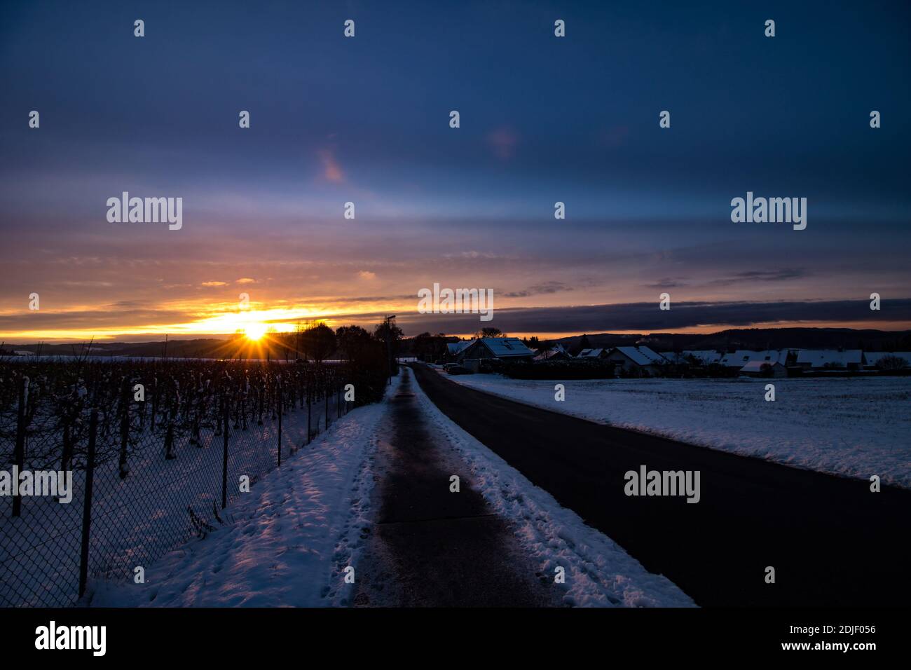 Snow Covered Field Against Sky During Sunset Stock Photo
