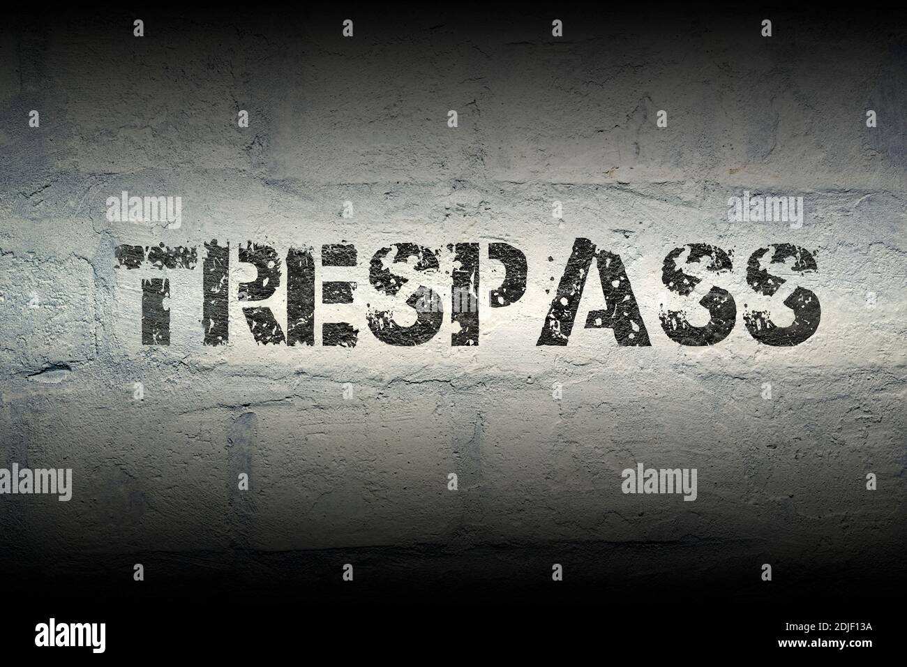trespass stencil print on the grunge white brick wall Stock Photo