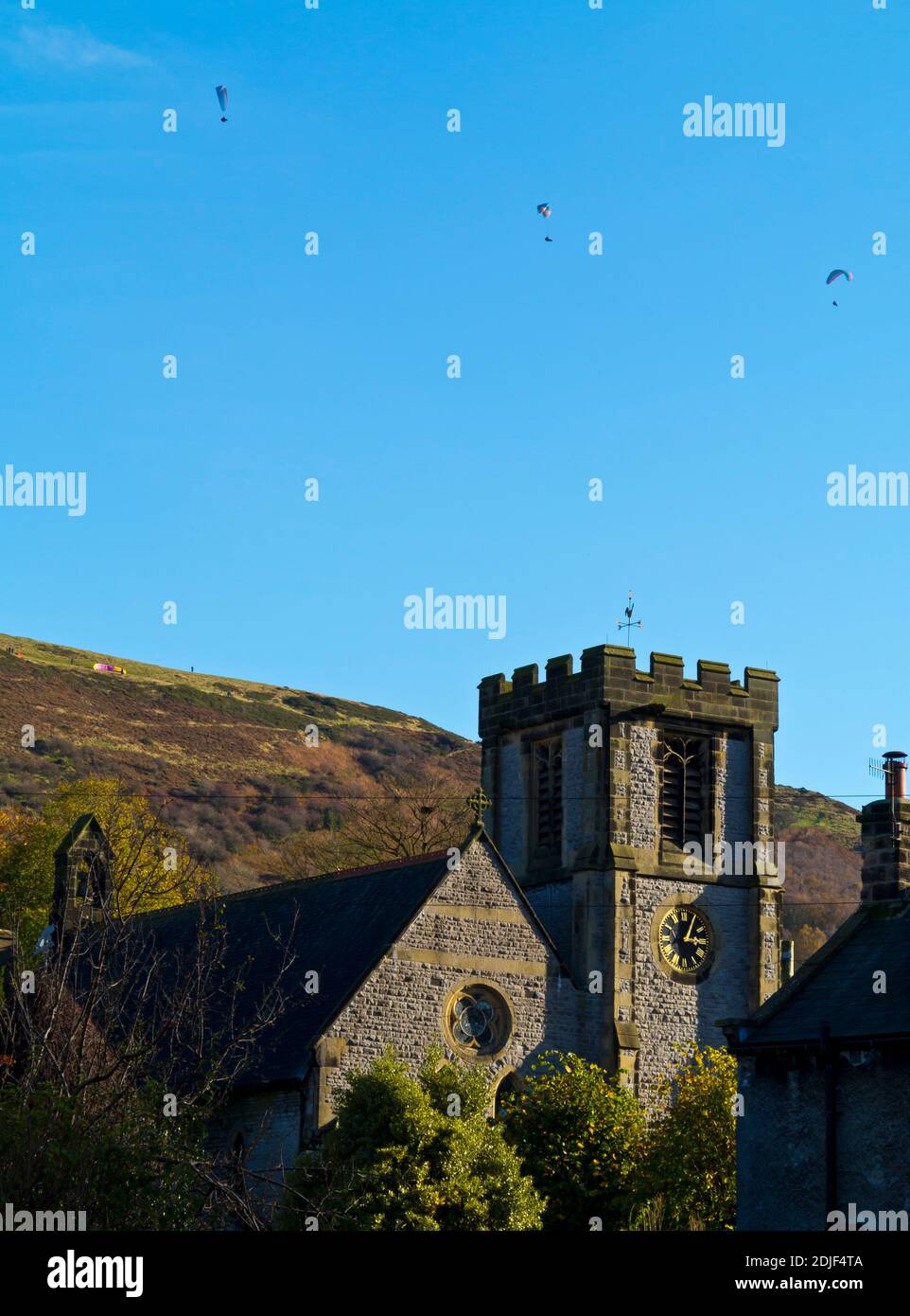 Paragliders in the sky above the Parish Church of St Barnabas in Bradwell a village in the High Peak Derbyshire England UK Stock Photo