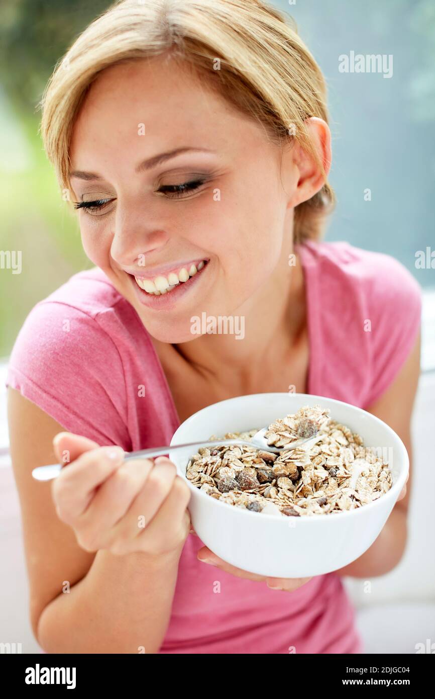 Beautiful woman eating bowl of cereal Stock Photo