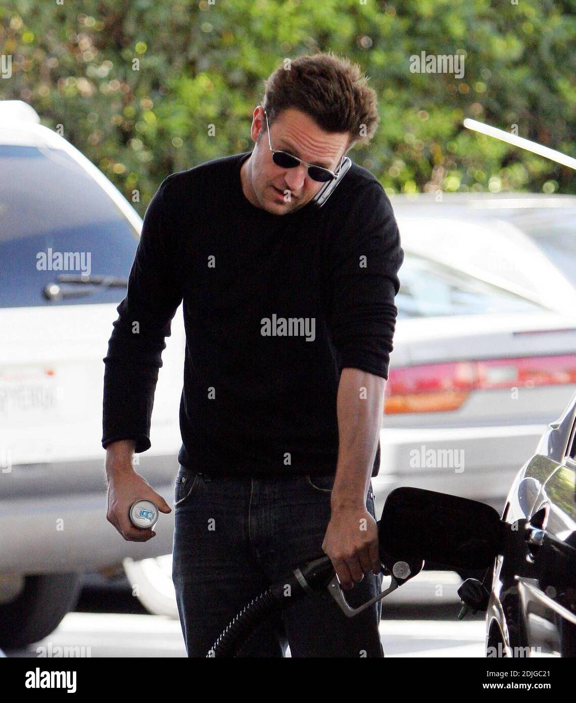 Exclusive!! Matthew Perry mutli tasks in Beverly Hills, Ca. The actor chatted on hi cell phone whilst filling up his gas tank and holding on to a can of the energy drink, diet Red Bull. 03/02/06 Stock Photo