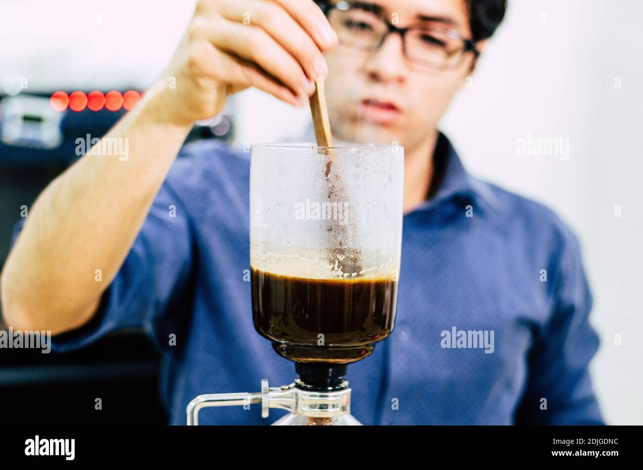 Professional coffee maker - Barista using coffee siphon brewing hot espresso at coffee shop Stock Photo