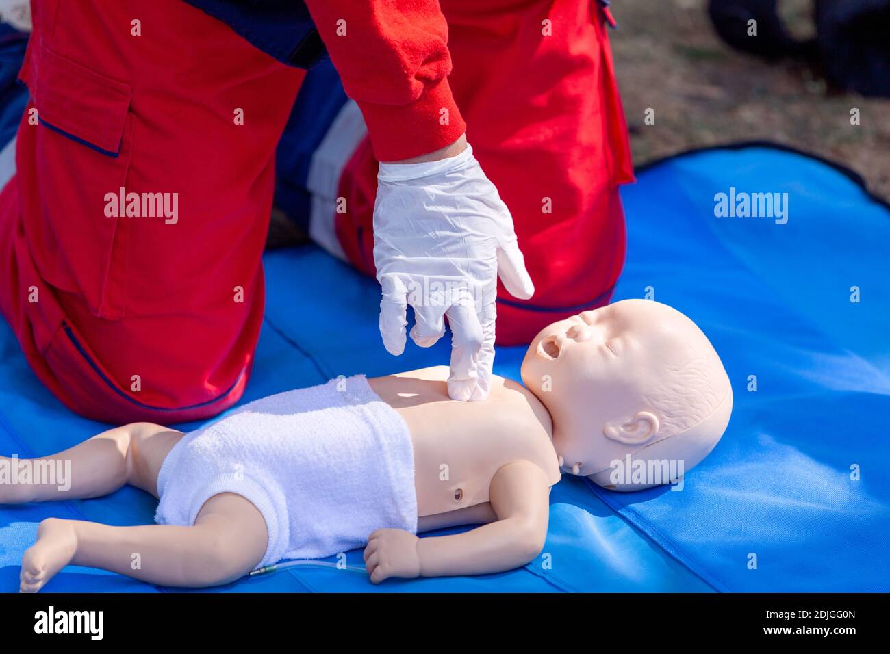 Paramedic performing CPR on baby dummy with twofinger chest