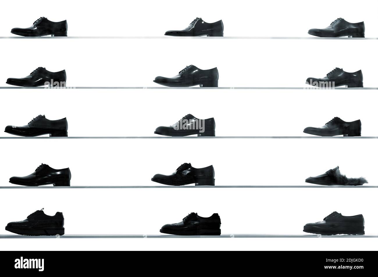 Men classic shoes displayed on shop shelves against back lit white background. High contrast black and white abstract looking picture Stock Photo