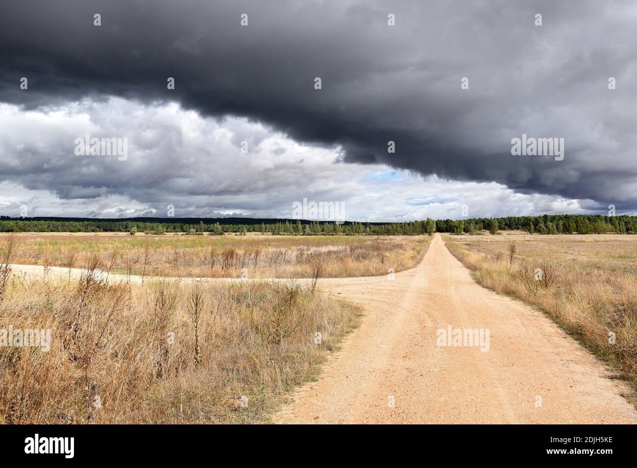 Crossroads with black clouds in the background cutting the sky. Stock Photo