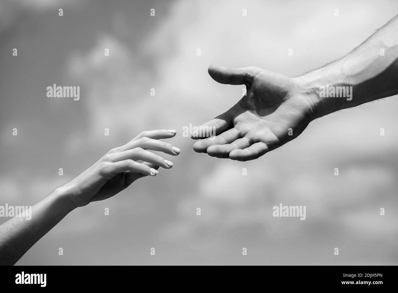 Solidarity, compassion, and charity, rescue. Hands of man and woman reaching to each other, support. Giving a helping hand. Lending a helping hand Stock Photo