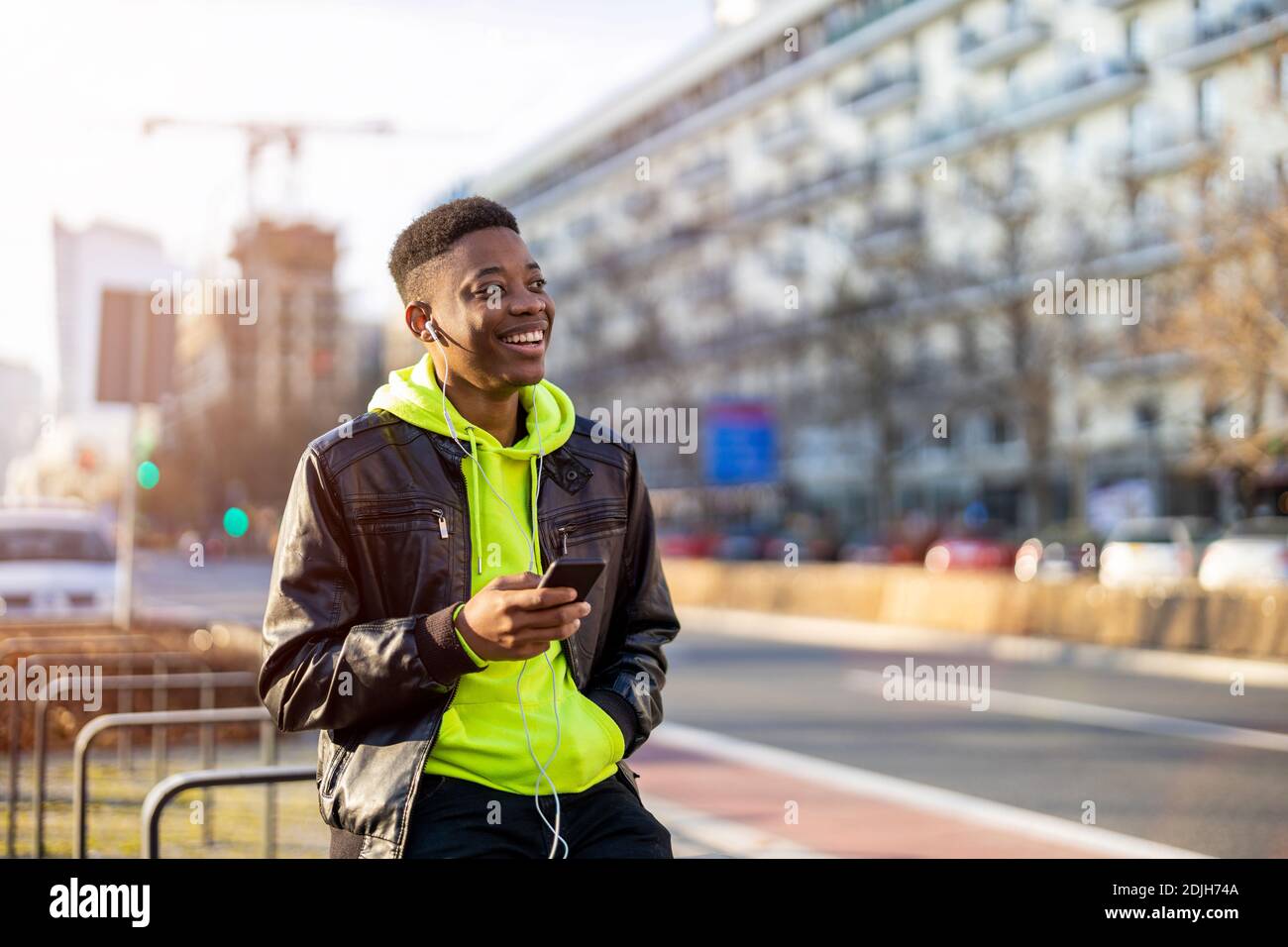 Young man using smart phone outdoors at urban setting Stock Photo