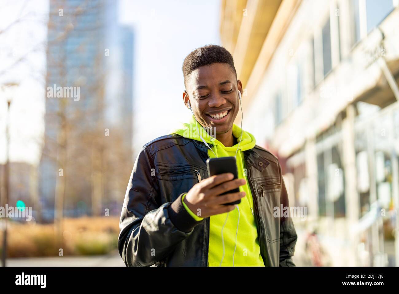 Young man using smart phone outdoors at urban setting Stock Photo
