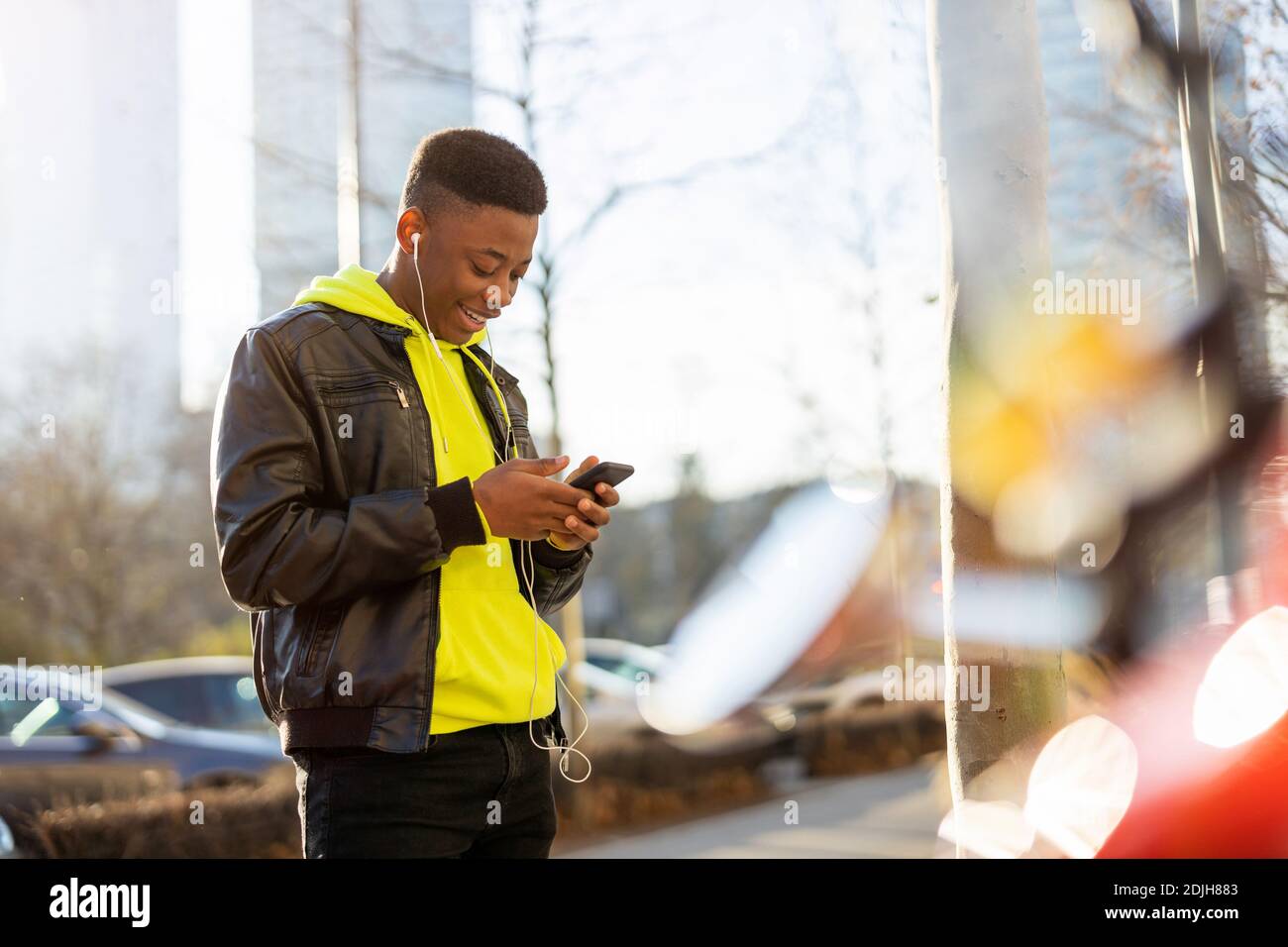 Young man using smart phone outdoors at urban setting Stock Photo