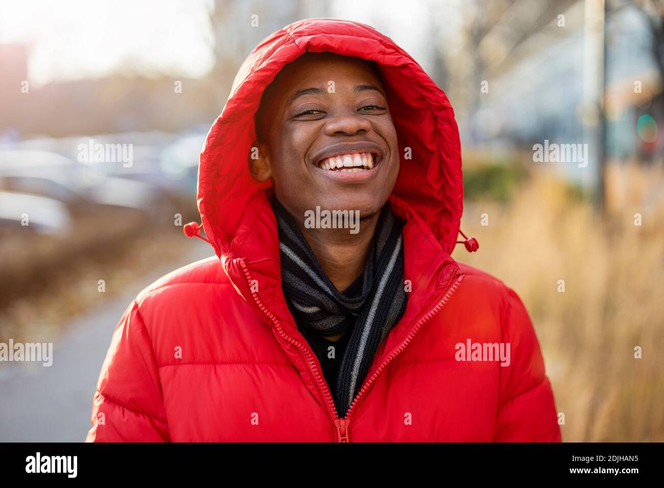 Laughing young man wearing a hood outdoors Stock Photo