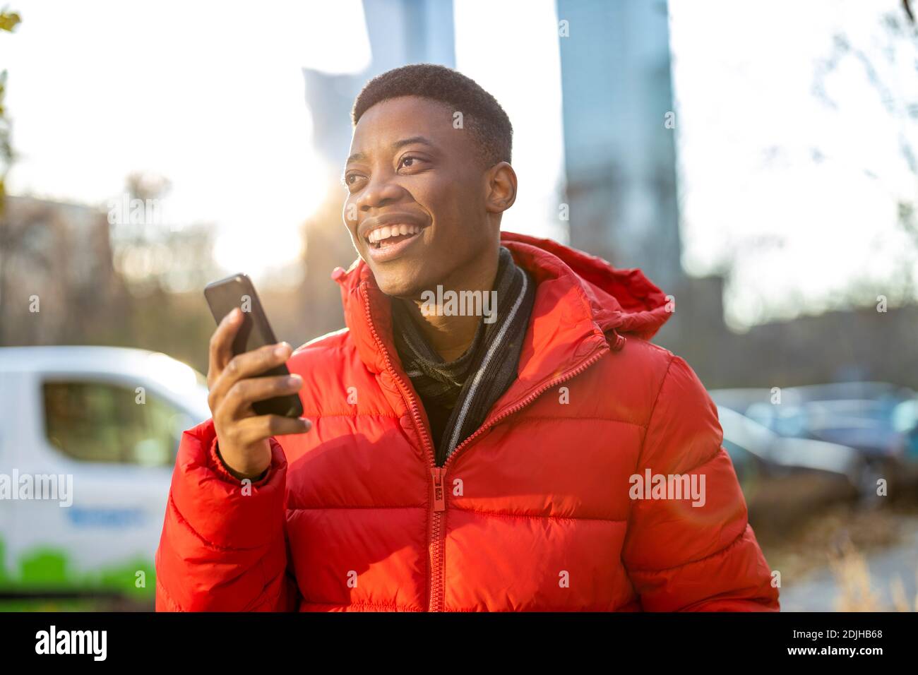 Young man using smart phone outdoors at urban setting Stock Photo