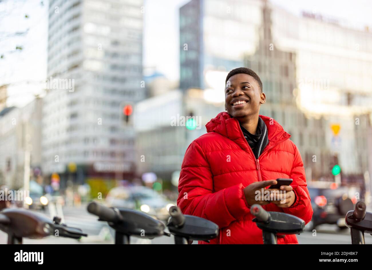 Young man using smart phone outdoors at urban setting Stock Photo