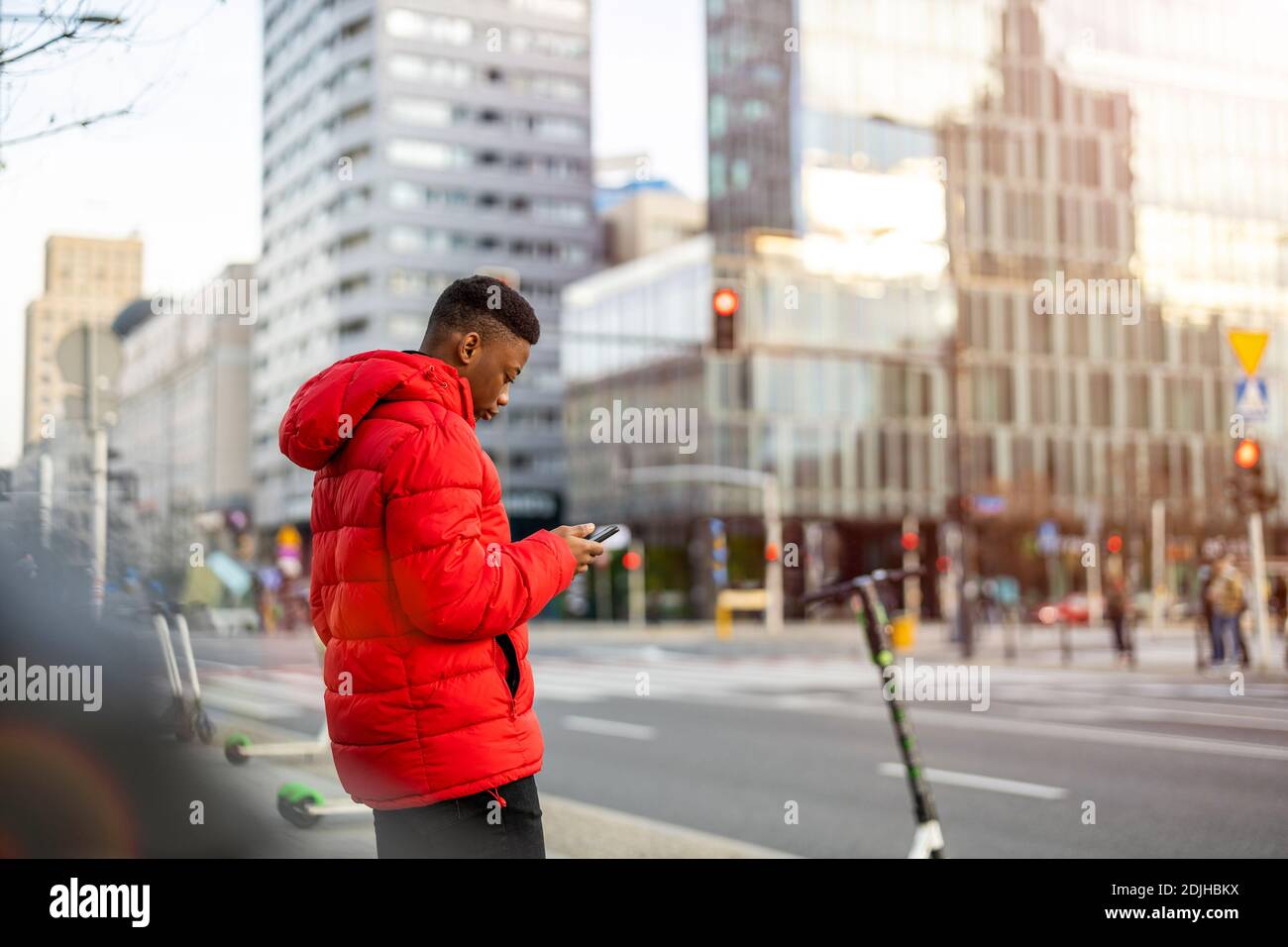 Young man using smart phone outdoors at urban setting Stock Photo