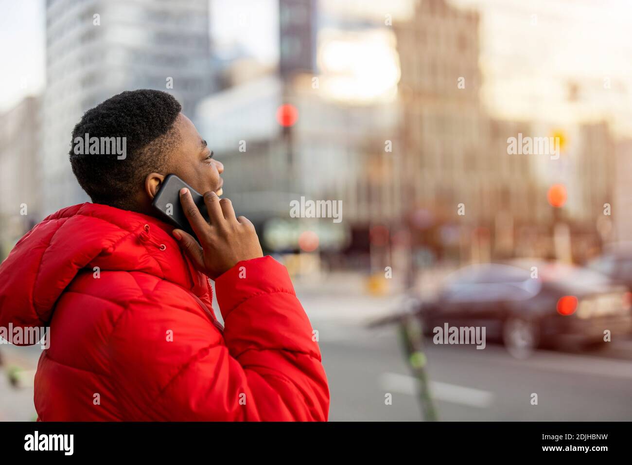 Young man using smart phone outdoors at urban setting Stock Photo