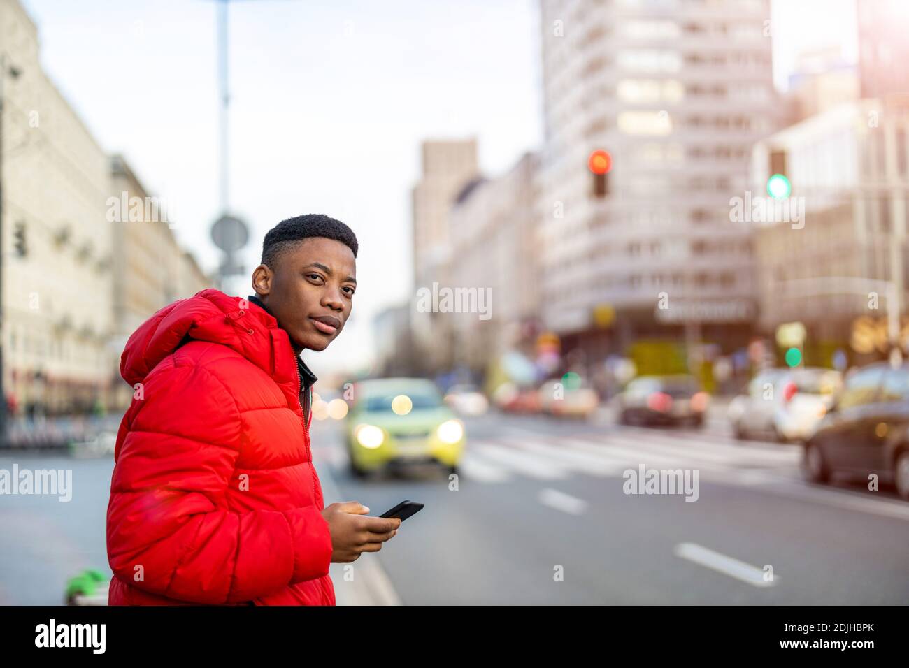 Young man using smart phone outdoors at urban setting Stock Photo