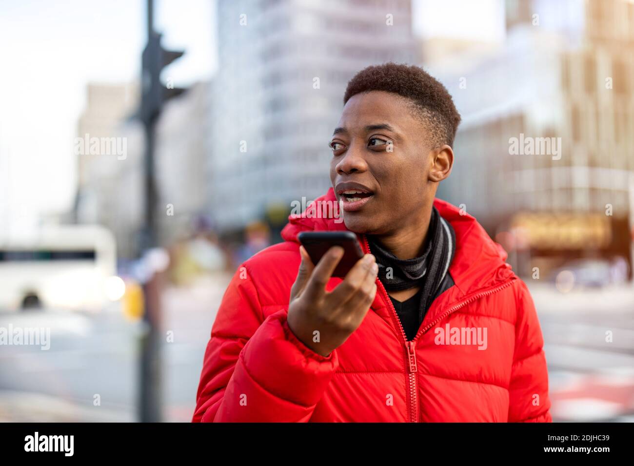 Young man using smart phone outdoors at urban setting Stock Photo