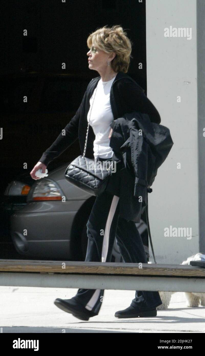 Exclusive!! Oscar winner Jane Fonda (68) arrives at Miami International Airport with her dog Tulea to appear at Miami Dade College's Wolfson Campus to promote her best selling book 'My Life So Far'.  Obviously Tulea was relieved to see the first available palm tree and in the absence of a pooper scooper Fonda removed the evidence with a white handkerchief. Miami, FL. 4/22/06 Stock Photo