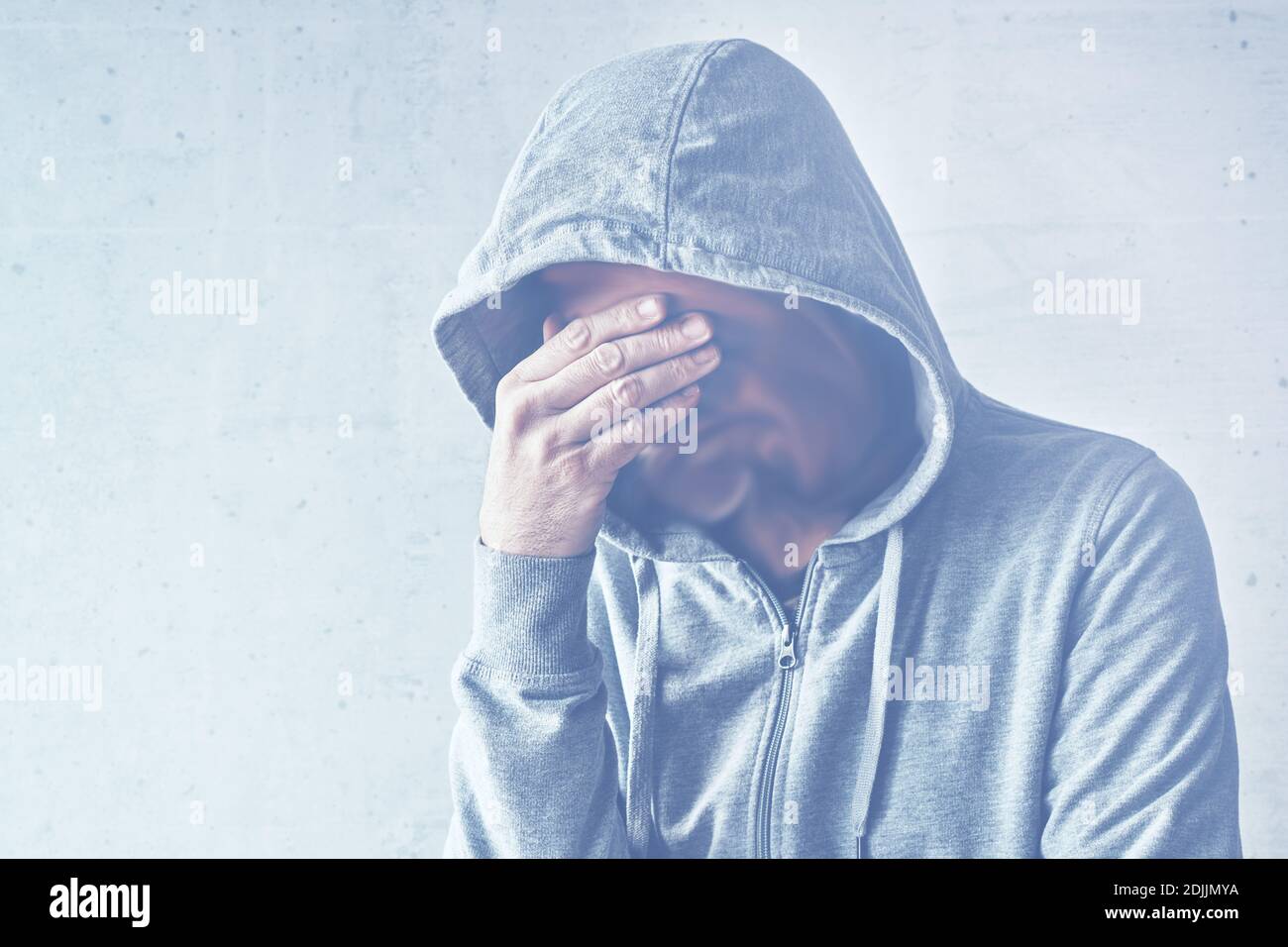 Schizophrenia and mental health illness concept, hooded male with melting face, copy space included Stock Photo