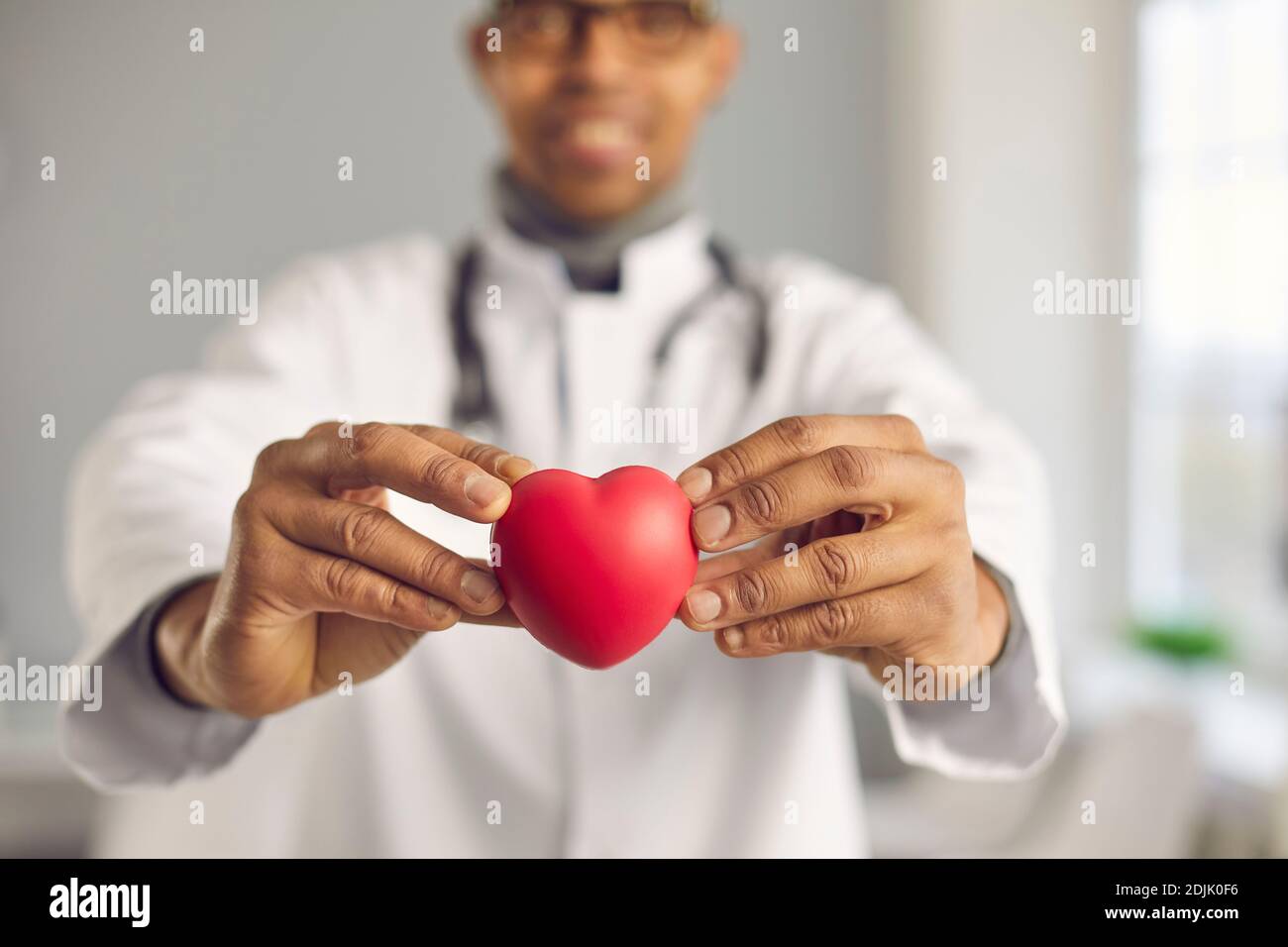 Doctor holding red heart and promoting healthy lifestyle and prevention of heart diseases Stock Photo