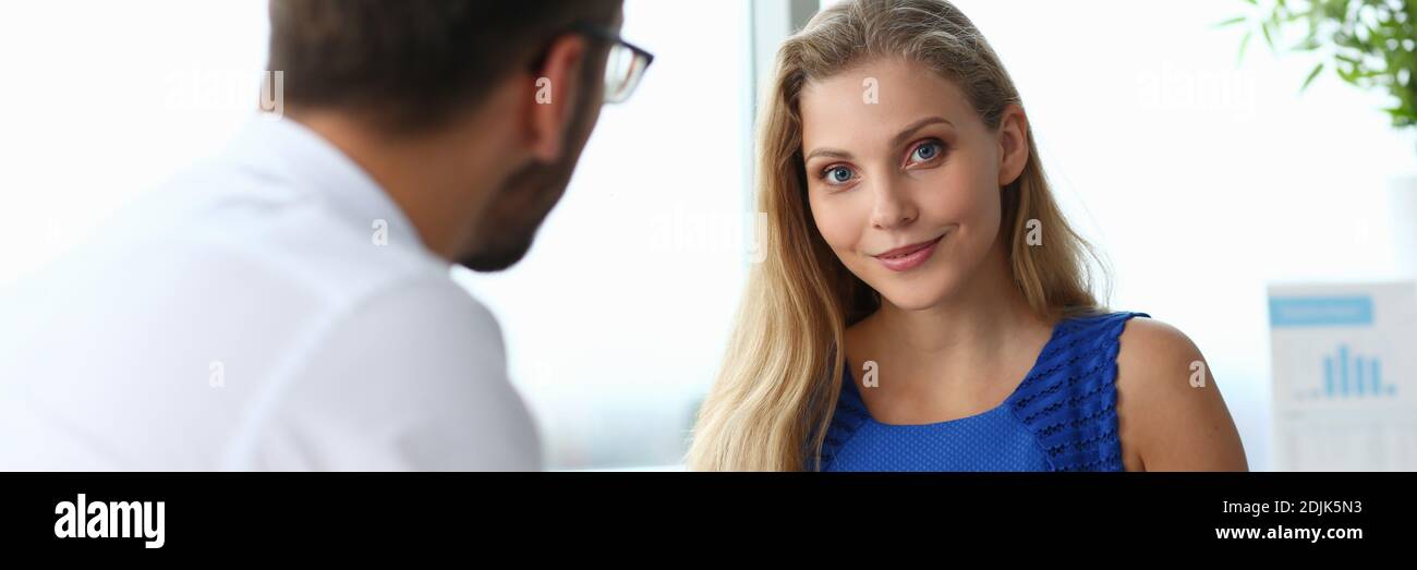 Charming young woman working with colleague in office Stock Photo