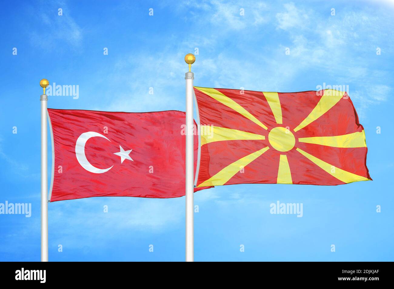 Turkey and North Macedonia two flags on flagpoles and blue cloudy sky Stock Photo