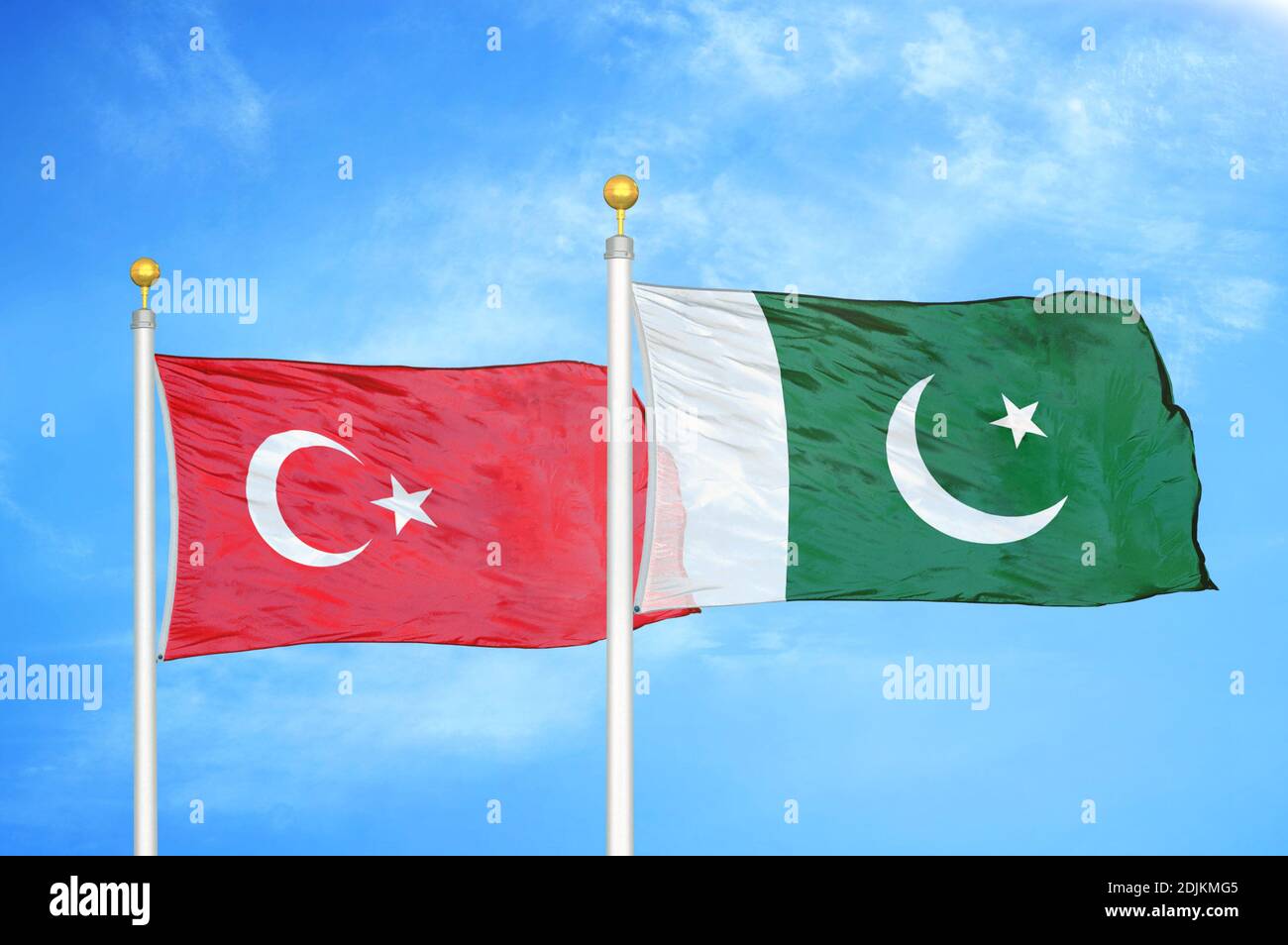 Turkey and Pakistan two flags on flagpoles and blue cloudy sky Stock Photo