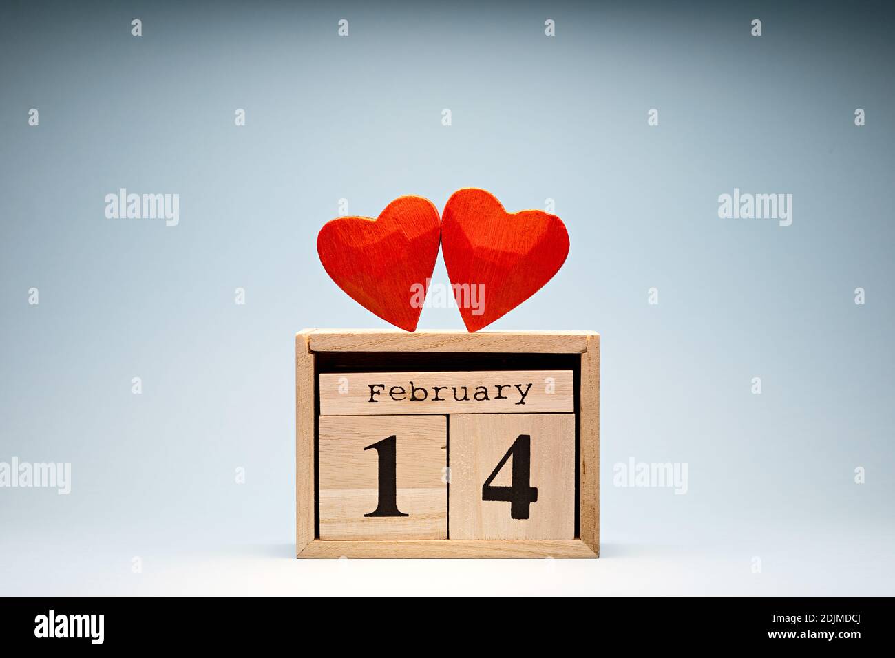 Love symbol tiny red hearts on wooden blocks calendar. February 14 Valentine's Day Stock Photo