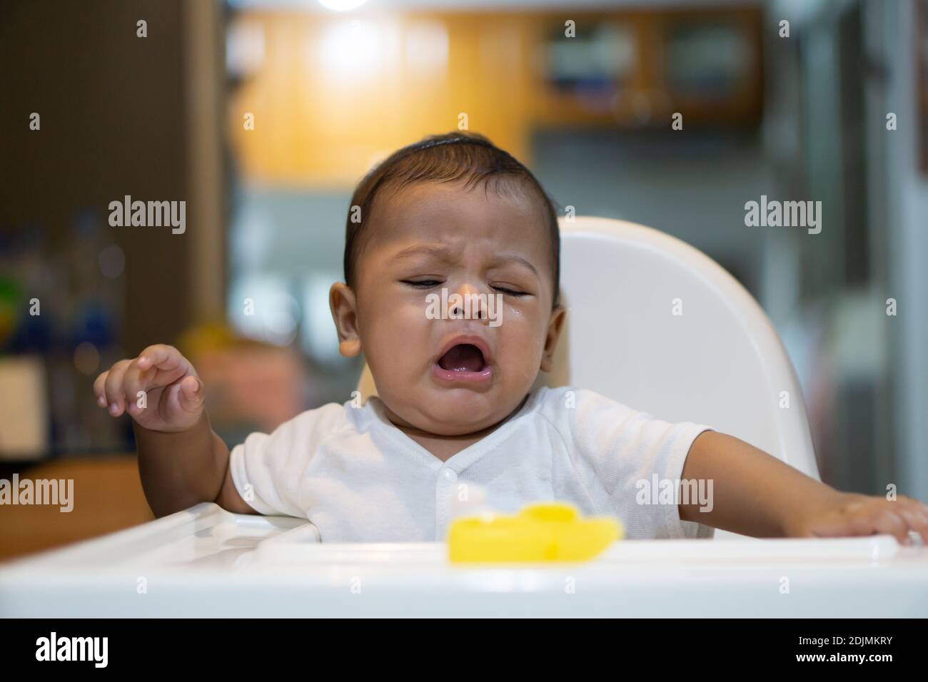 Crying baby boy sitting on chair hires stock photography and images