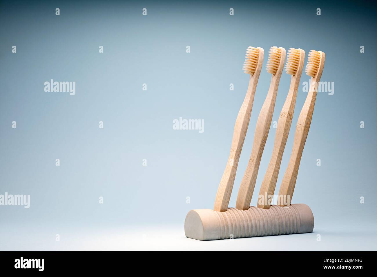 Eco-friendly wooden toothbrushes in a concrete stand Stock Photo