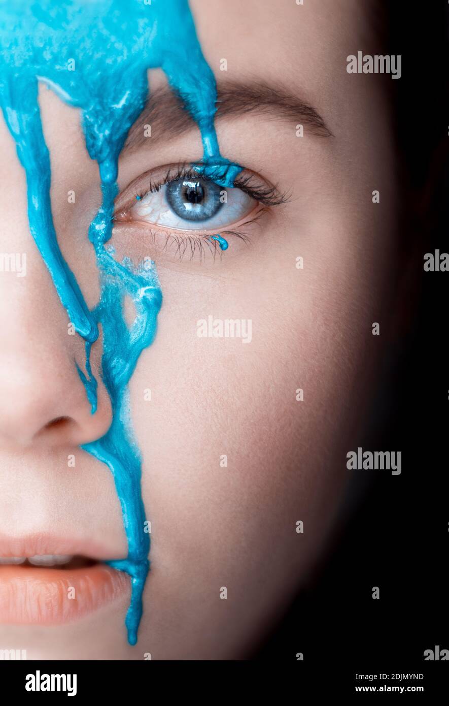 Close-up Portrait Of Woman With Blue Paint On Face Stock Photo
