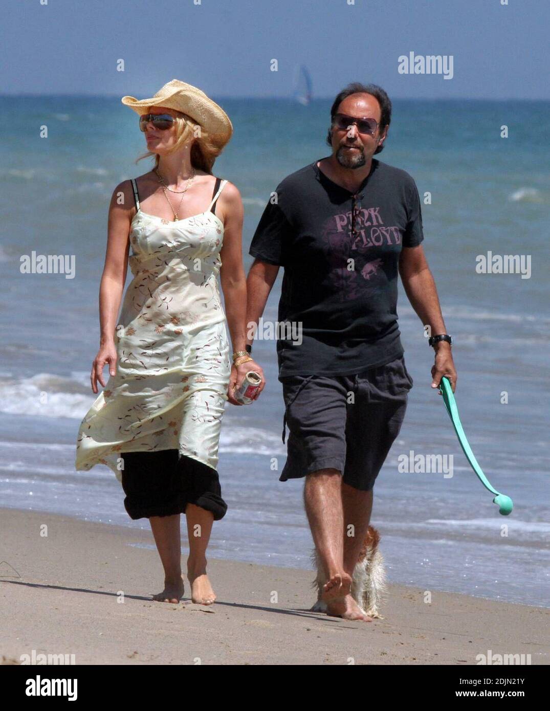 Rosanna Arquette takes a stroll on the beach with a friend while playing  fetch with some dogs. Perhaps the actress is litter-conscious, as she  appears to be toting away a canister of