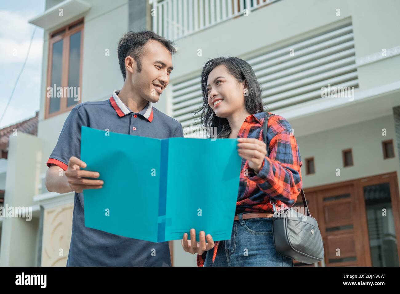 male housing developers show home certificates to customers with new home backgrounds Stock Photo