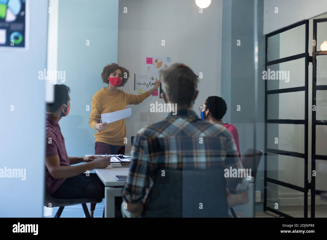 Diverse group of colleagues wearing masks in office meeting Stock Photo ...