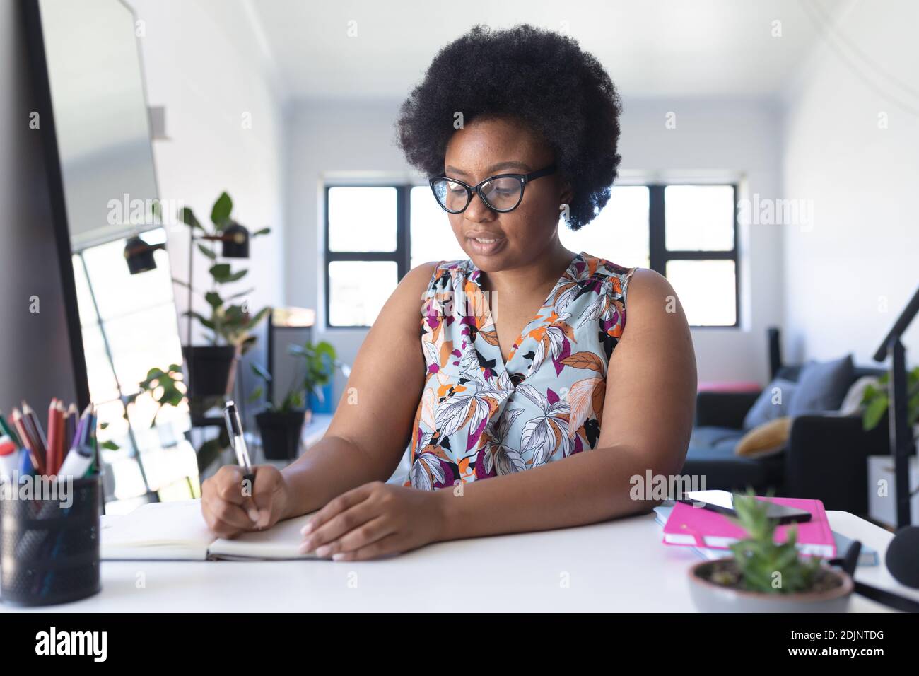 African american female vlogger recording a video writing in notebook Stock Photo