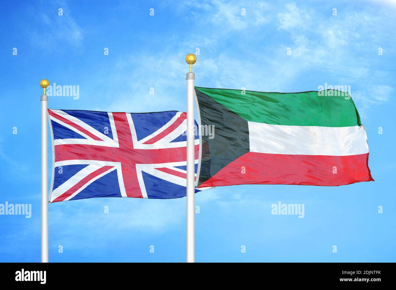 United Kingdom and Kuwait two flags on flagpoles and blue cloudy sky Stock Photo
