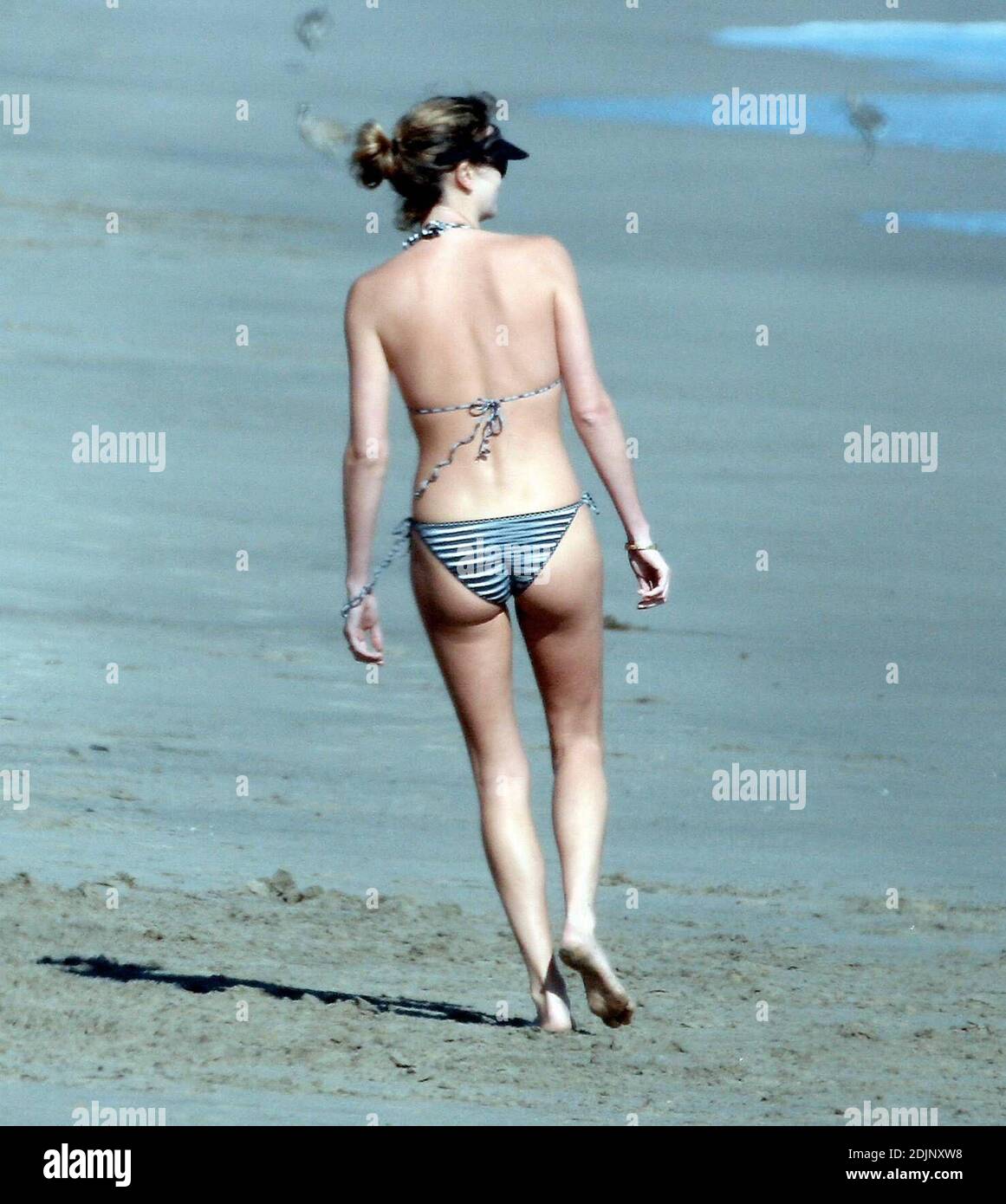 Charlize Theron spends an afternoon on the beach in Malibu, Ca. with a pal  and her dogs. The actress kept tugging at her tiny bikini as she played  with her pooches. 8/26/06