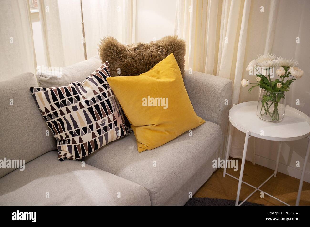 Cushions On Sofa By Vase At Home Stock Photo
