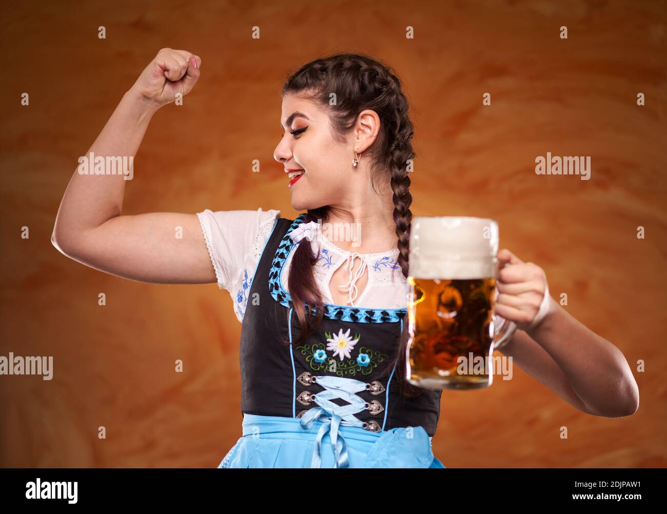 German girl in traditional costume serving large pints of lager Stock ...