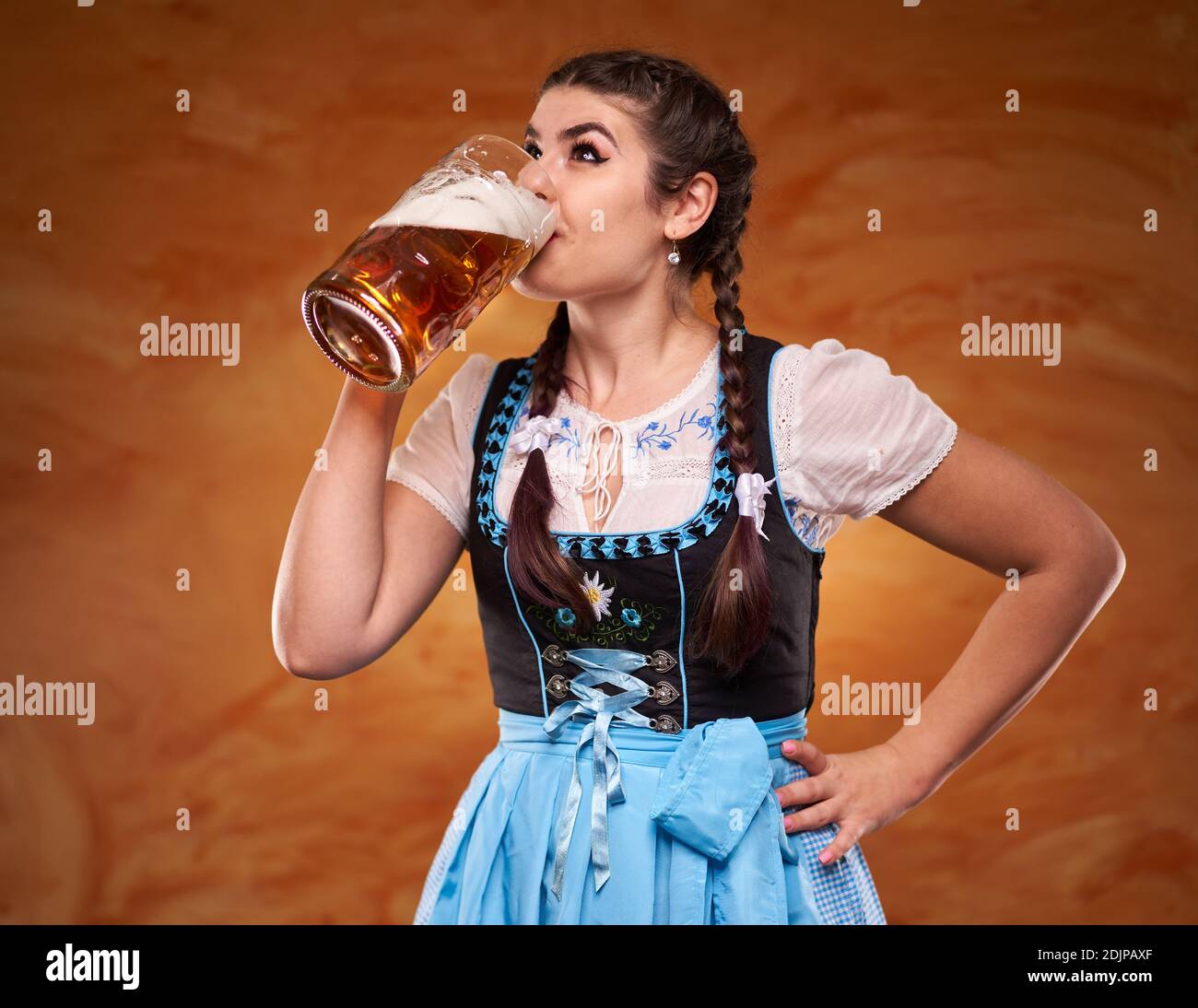 German girl in traditional costume drinking large pints of lager Stock ...