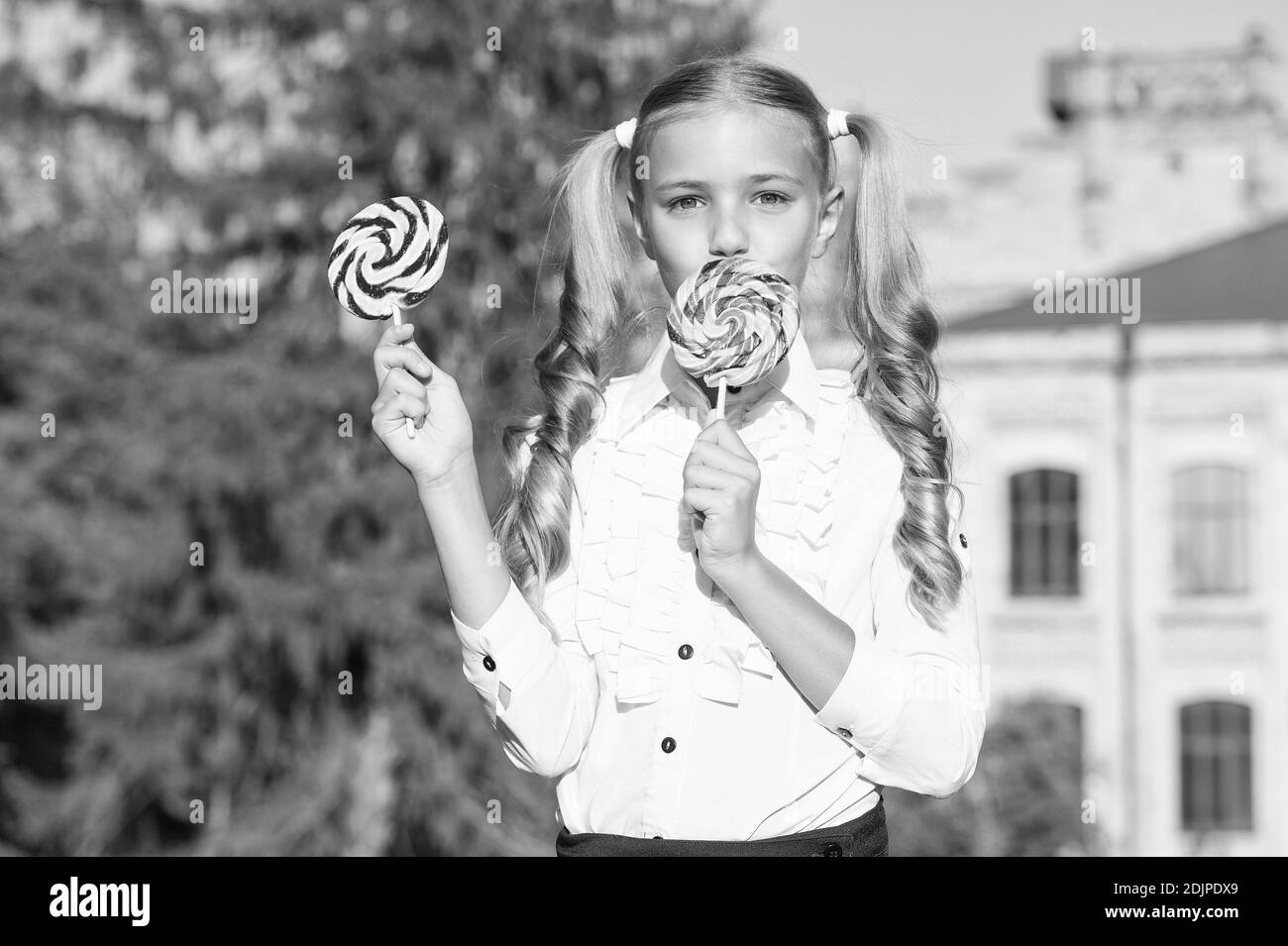 Lollipop melting in your mouth. Happy child eat lollipop summer outdoors. Enjoying large swirl