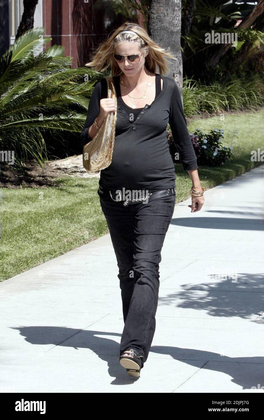 A pregnant Heidi Klum flaunts her bump in a tight fitting top and wears