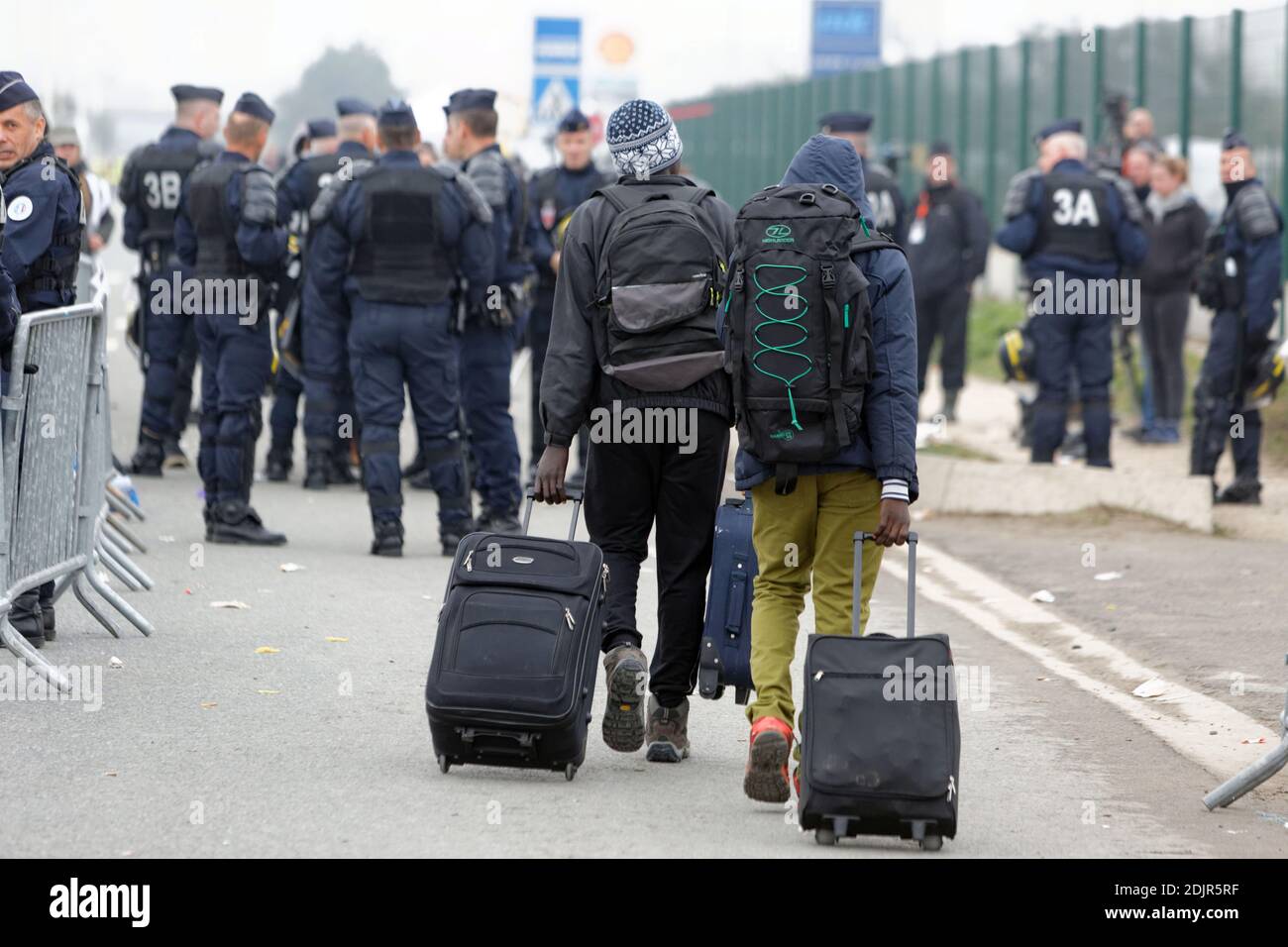 A coach carrying migrants leaves after they registered at a processing centre in 'the jungle' near Calais, northern France, as the mass exodus from the migrant camp begins. Calais, France, Monday October 24, 2016. Police vans and fire engines had gathered on the perimeter of the rat-infested slum as migrants and refugees queued in the dark to register for accommodation centres elsewhere in France after being told they must leave the camp or risk arrest and deportation. Photo by Sylvain Lefevre/ABACAPRESS.COM Stock Photo