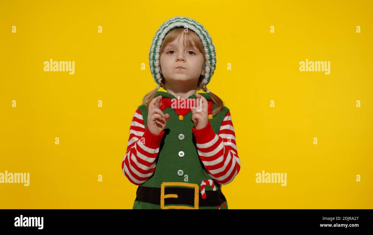 Christmas Wish Concept Little Fun Blonde Kid Teen Teenager Girl In Christmas Elf Santa Helper Costume Hopes For Dreams Come Making A Wish Fingers Crossed Prays For Better Life Shy Smiling Child