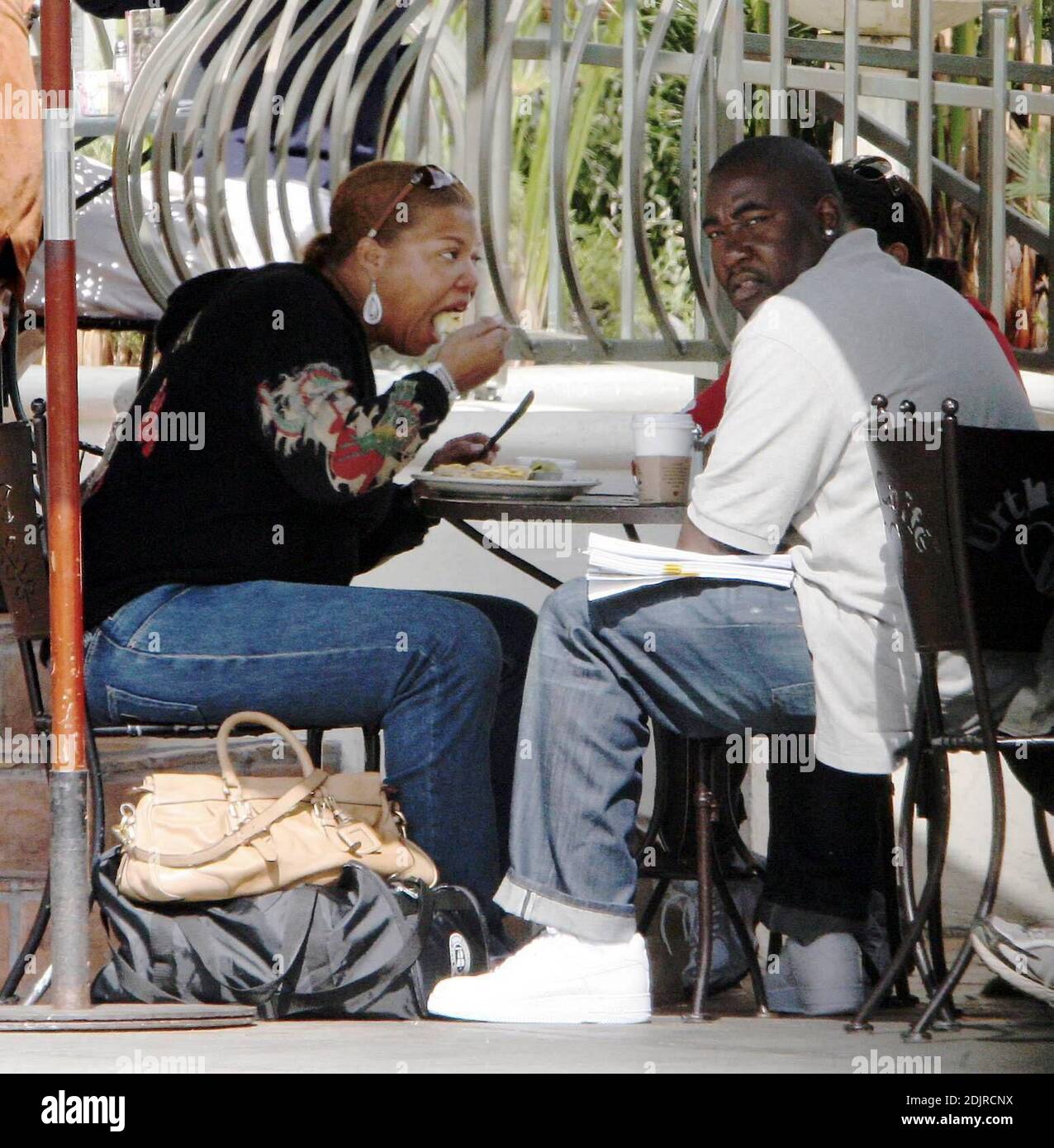 Queen Latifah seems happy to sign a pile of documents over brunch in West Hollywood, Ca. at the Urth Cafe. 10/14/06 Stock Photo