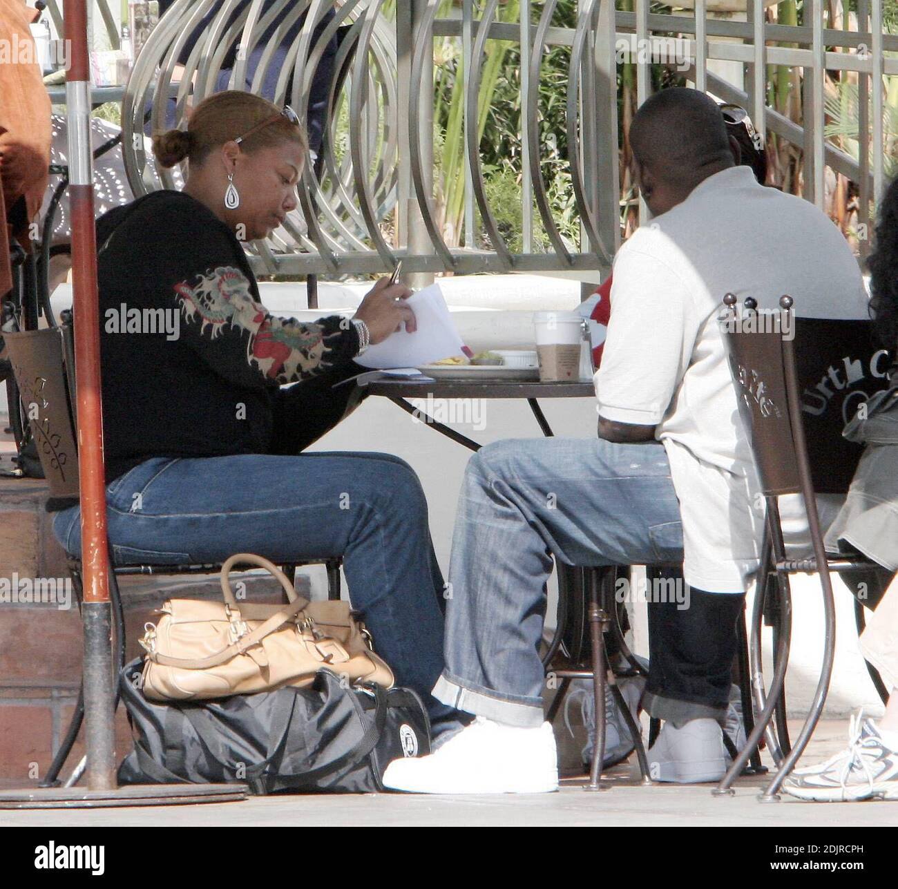 Queen Latifah seems happy to sign a pile of documents over brunch in West Hollywood, Ca. at the Urth Cafe. 10/14/06 Stock Photo