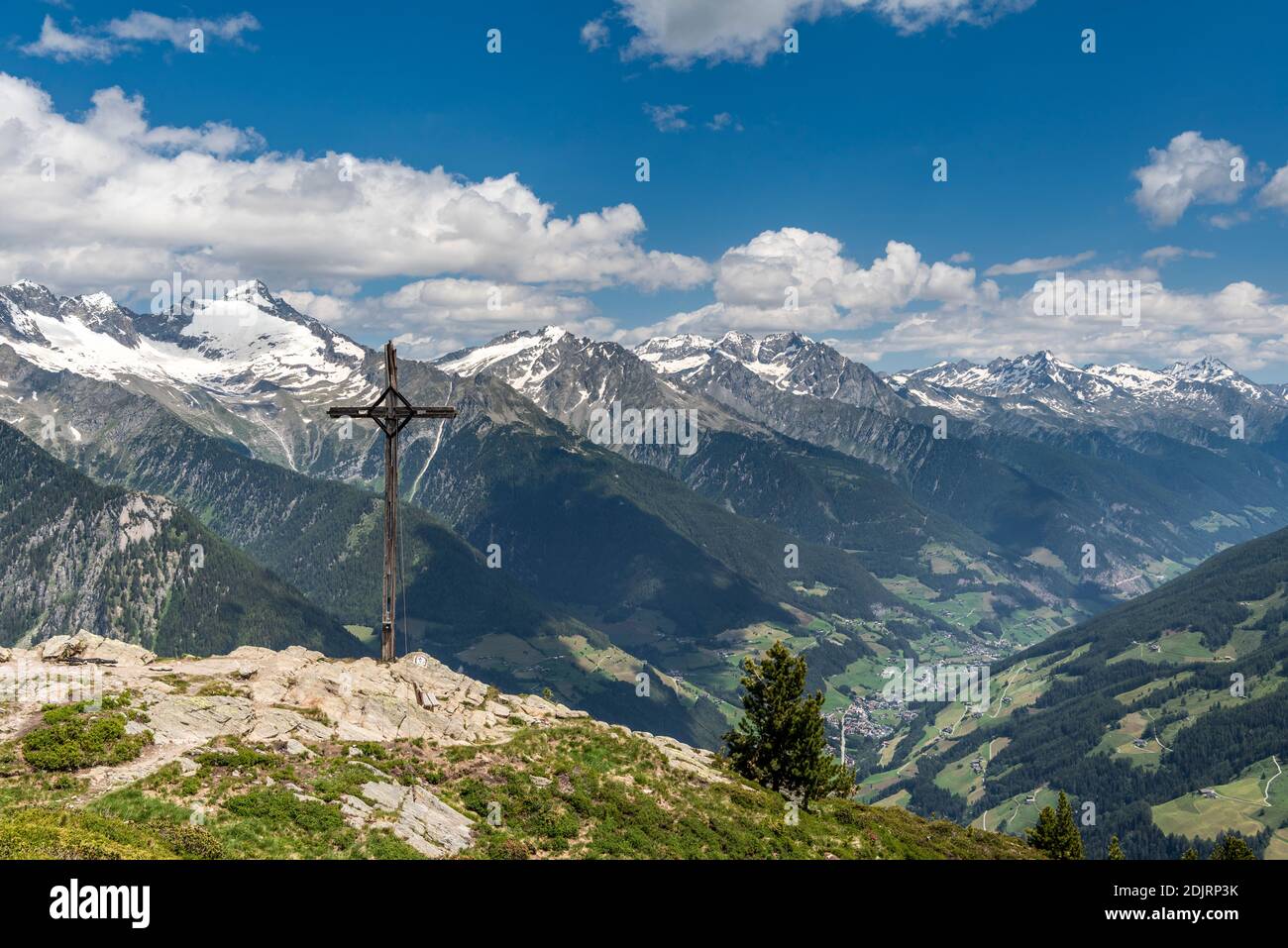 Sand in Taufers, Bolzano Province, South Tyrol, Italy. The summit cross on the Kleiner Nock in the Speikboden hiking area. In the background the Ahrntal with the Zillertal Alps Stock Photo