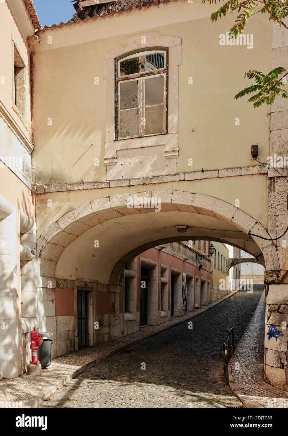Narrow street leading up to arch in Lisbon Stock Photo